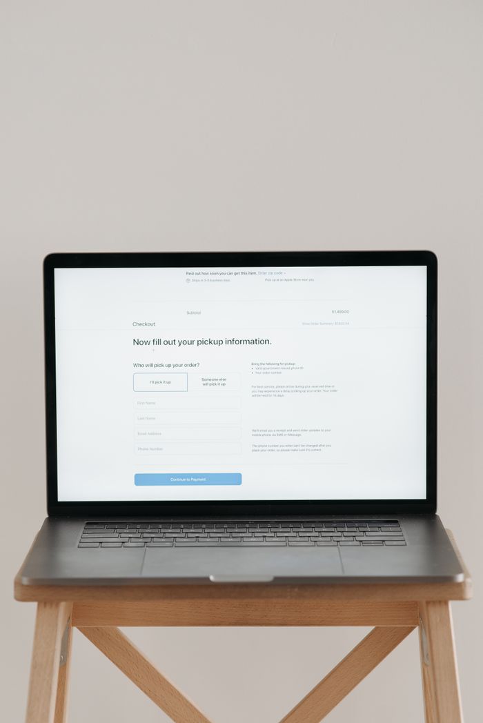 get-in-touch Modern laptop displaying a checkout form against a minimalist beige backdrop.